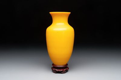A Chinese yellow Peking glass vase on a wooden stand, 19th C.
