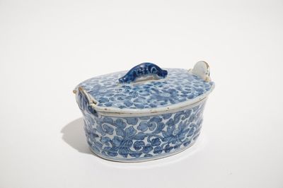 A Dutch Delft blue and white butter tub with chinoiserie design of peony scrolls, 18th C.