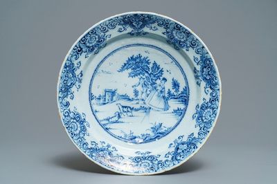 A Dutch Delft blue and white dish with a couple playing blind man's buff, 18th C.