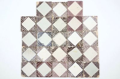 A field of 23 manganese Dutch Delft diamond tiles, 17/18th C.