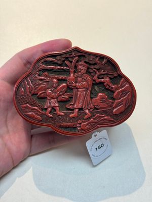 A fine Chinese red cinnabar lacquer ruyi-form 'Ba Man Xian Bao 八蠻獻寶' box and cover, Qianlong — photo 1