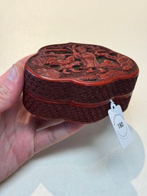 A fine Chinese red cinnabar lacquer ruyi-form 'Ba Man Xian Bao 八蠻獻寶' box and cover, Qianlong — photo 2