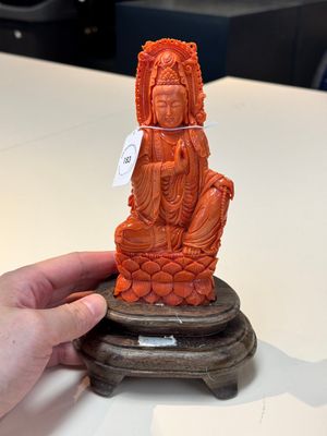 A fine Chinese red coral sculpture of Guanyin seated on a lotus throne on a wooden stand, 19/20th C. — photo 1