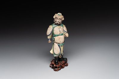 A fine Chinese verte biscuit figure of a warrior on wooden stand, Kangxi
