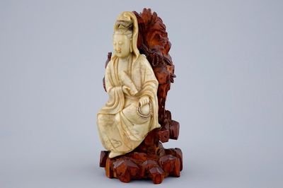 A fine figure of a Guanyin in soapstone on a wooden base, 18/19th C.