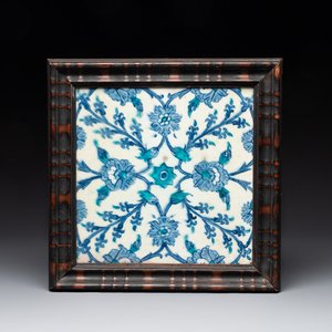 A framed blue, white and turquoise Iznik pottery tile with floral design, Turkey, 17th C. — photo 1