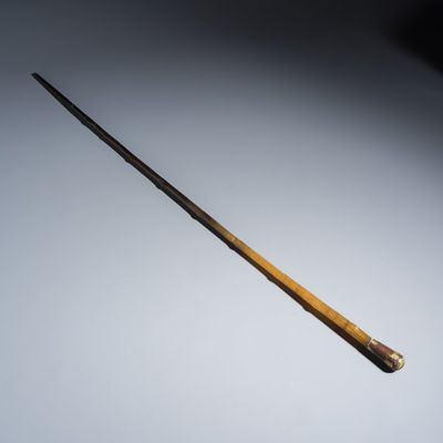 A honey-brown rhinoceros horn swagger stick with a gilt-copper knob, late 19th C.