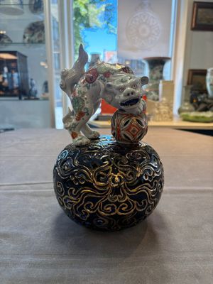 A Japanese Kutani group of a Shishi standing on an openworked brocade ball, 20th C. — foto 1