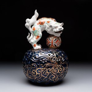 A Japanese Kutani group of a Shishi standing on an openworked brocade ball, 20th C. — foto 1