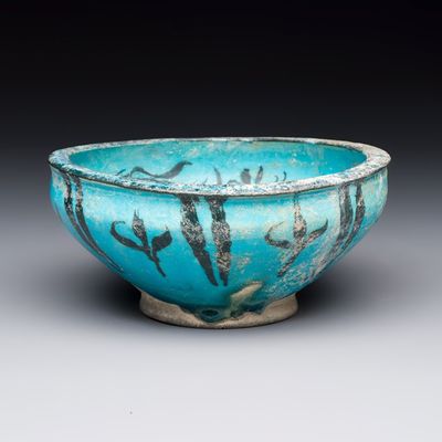 A Kashan black and turquoise pottery bowl with water-weed design, Persia, 13th C.