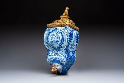 A large blue and white Dutch Delft 'Fountain of Youth' wall cistern with impressive reticulated gilt bronze cover, 18th C.