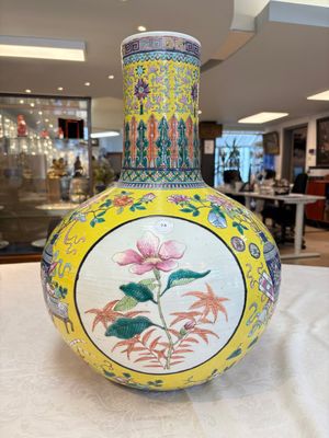A large Chinese famille rose yellow-ground 'tianqiu ping' vase with flowers and antiquities, 19th C. — photo 1