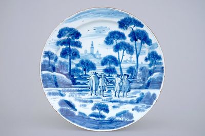 A large Dutch Delft blue and white dish with noblemen in a landscape setting, 18th C.