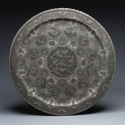 A large Persian engraved tinned-copper dish with narrative design, 19/20th C.