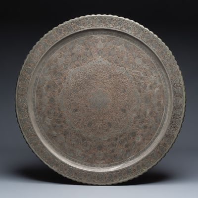 A large Persian engraved tinned-copper tray with stags and birds among flowers, 19/20th C.