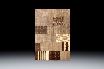 A large Persian hand-knotted woollen carpet with a geometric patchwork design, 20th C.