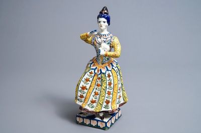 A large polychrome Dutch Delft model of a lady with a dog, 18th C.