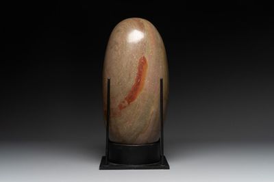 A large Shiva lingam stone on a metal stand