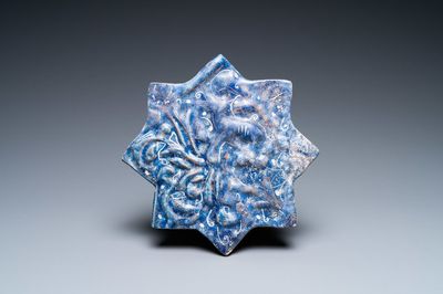 A molded Ilkhanid Lajvardina blue-ground star-shaped tile, Iran, 13/14th C.