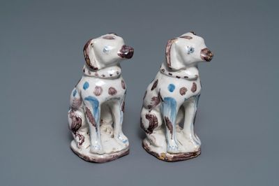 A pair of blue, white and manganese Brussels faience models of dogs, 18th C.