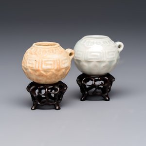A pair of Chinese bird feeders with moulded design, one unglazed, on later wooden stands, Song — photo 1