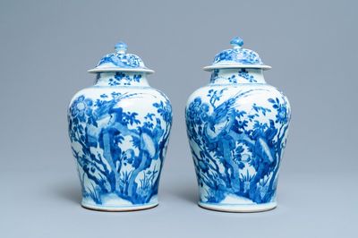 A pair of Chinese blue and white baluster vases and covers with birds in a rocky setting, Kangxi