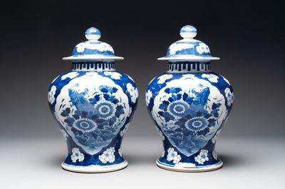 A pair of Chinese blue and white covered vases with floral design, 19th C.
