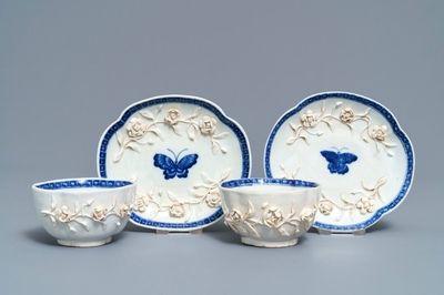 A pair of Chinese blue and white 'soft paste' relief-decorated cups and saucers, Qianlong