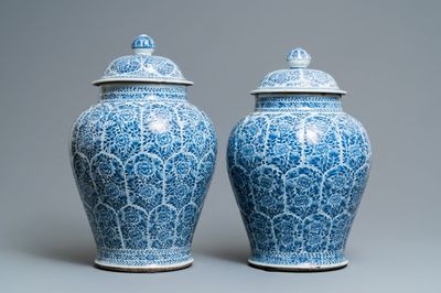 A pair of Chinese blue and white vases and covers with floral design, Kangxi