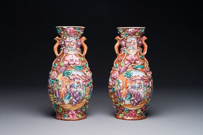 A pair of Chinese Canton famille rose 'mandarin subject' vases with floral relief design, Qianlong