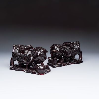 A pair of Chinese carved cherry amber 'Buddhist lions' groups, 20th C.