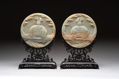 A pair of Chinese carved jade ‘elephant’ plaques on wooden stands, 19th C.
