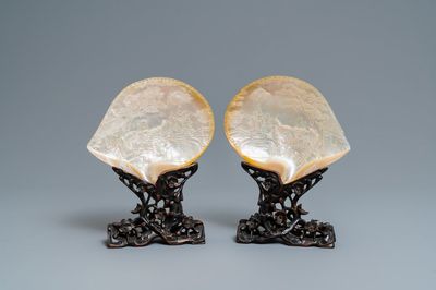 A pair of Chinese carved mother-of-pearl shells on wooden stands, 19th C.