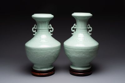 A pair of Chinese celadon-glazed vases with 'anhua' design on wooden stands, Qianlong mark, 19th C.