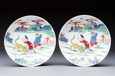 A pair of Chinese famille rose 'Taming the Tiger' saucers, Yongzheng