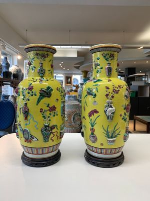 A pair of Chinese famille rose yellow-ground relief-decorated vases with wooden stands, 19th C. — photo 1