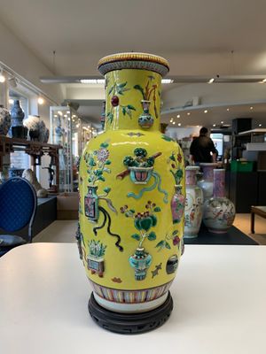 A pair of Chinese famille rose yellow-ground relief-decorated vases with wooden stands, 19th C. — photo 3