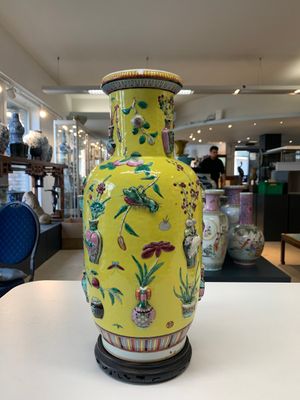 A pair of Chinese famille rose yellow-ground relief-decorated vases with wooden stands, 19th C. — photo 4