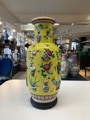 A pair of Chinese famille rose yellow-ground relief-decorated vases with wooden stands, 19th C. — photo 5