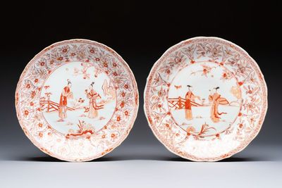 A pair of Chinese iron-red and gilt-decorated 'Elegant Beauties in a Garden' dishes, Kangxi