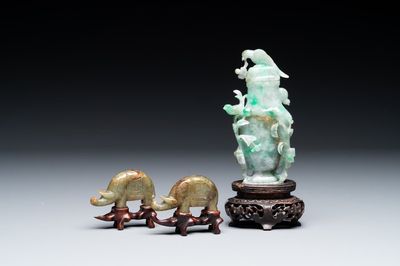 A pair of Chinese jade sculptures of elephants and a covered vase on wooden stands, 19th C.