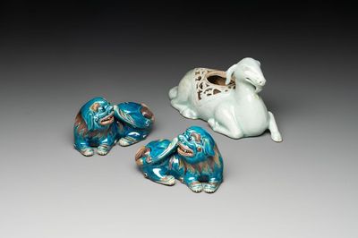 A pair of Chinese polychrome lions and a celadon-glazed goat, 20th C.