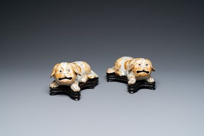 A pair of Chinese porcelain models of reclining dogs, Qianlong/Jiaqing