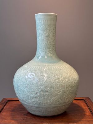A pair of large Chinese monochrome celadon-glazed anhua 'lotus scroll' bottle vases, 19th C. — photo 1