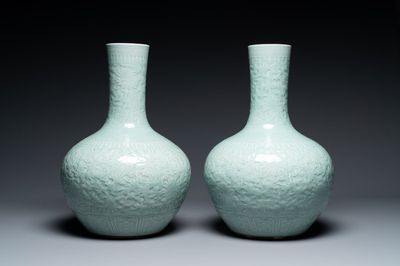 A pair of large Chinese monochrome celadon-glazed anhua 'lotus scroll' bottle vases, 19th C.