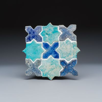 A panel of nine Kashan turquoise- and blue-glazed star and cross tiles, Persia, 12/13th C.