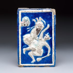 A Persian relief-moulded blue-ground tile depicting Fateh 'Ali Shah in the guise of Rustam slaying the White Div, Qajar, 19th C. — foto 1