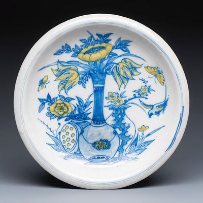 A polychrome Dutch Delft chinoiserie dish with flower vases, a bird and insects, 17th C.