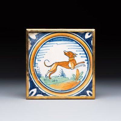 A polychrome Dutch Delft maiolica medallion tile with a leaping dog, 16th C.