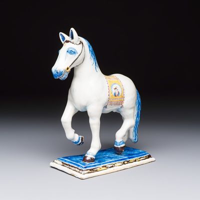 A polychrome Dutch Delft model of a standing horse with a figurative saddle cloth, 18th C.